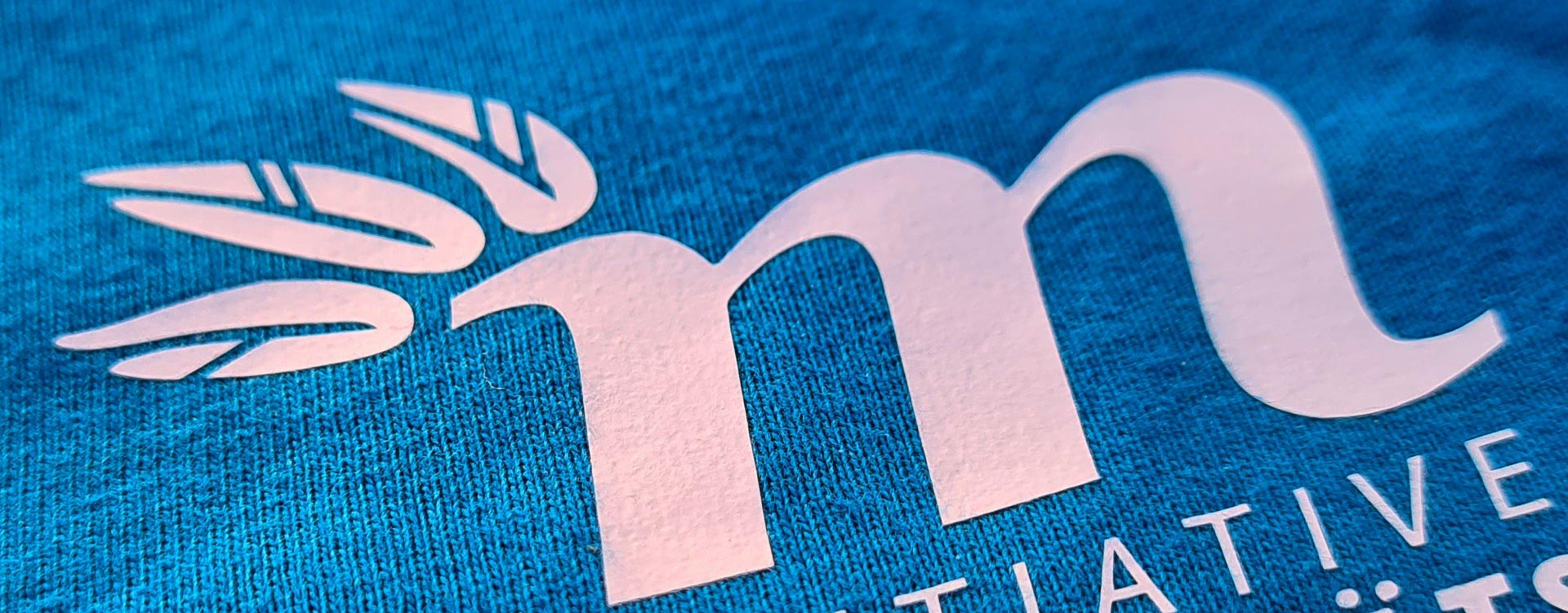 Logodesign for the MOBILITY CULTURE INITIATIVE - in German Initiaive Mobilit&aumltskultur. The Logo closeup on a shirt