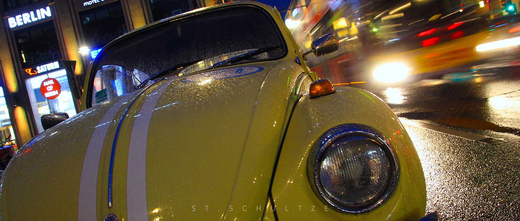One that always makes people smile: A well restaurated beautiful vintage VW Beetle oldtimer in Berlin on a rainy day while a Bus passed by – PHOTOGRAPHY by Stefan Schultze. vintage car, vwbeetle, iconic car, Berlin oldtimer, mobility, car photography. iconic photography