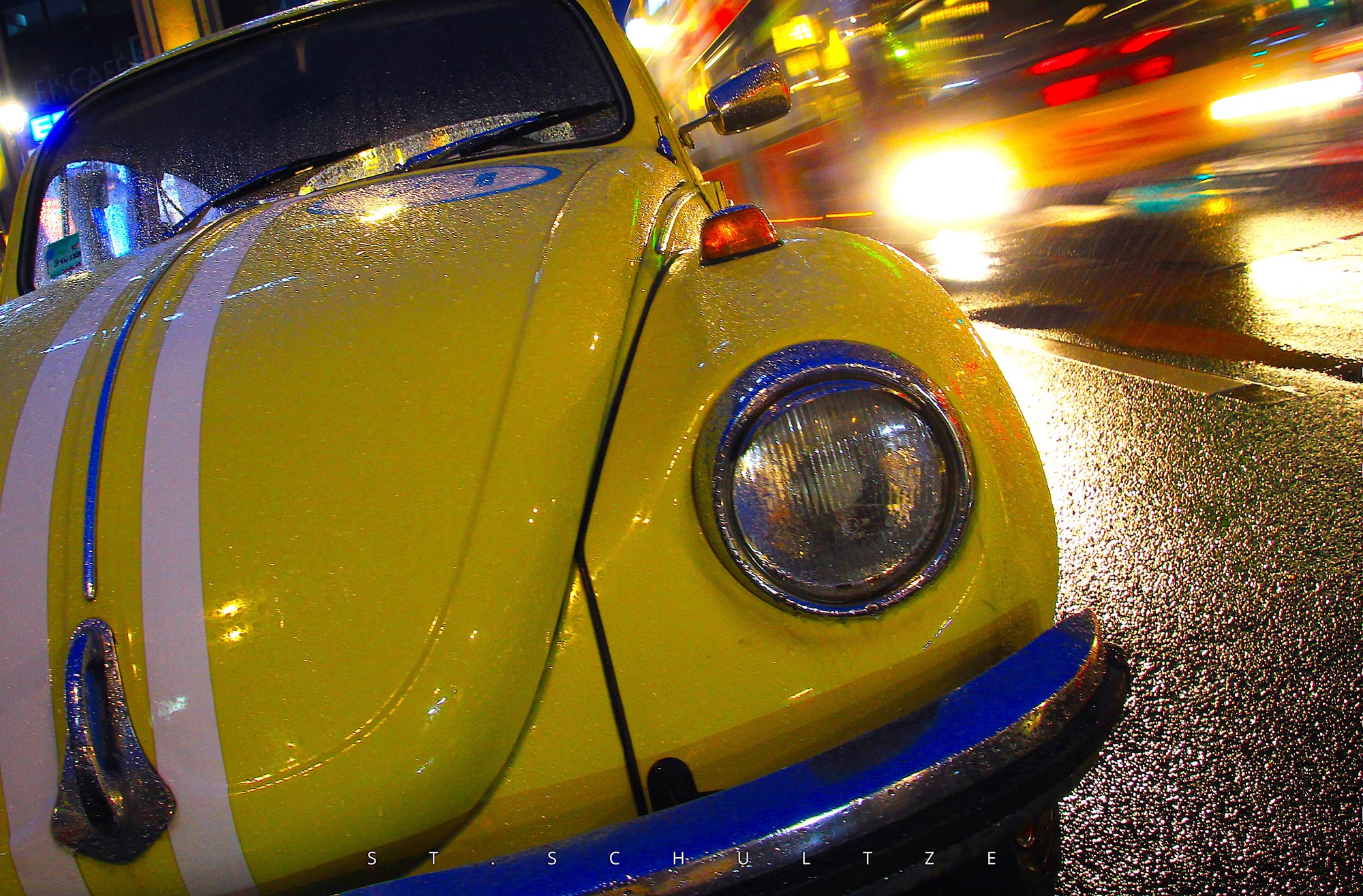 One that always makes people smile: A well restaurated beautiful vintage VW Beetle oldtimer in Berlin on a rainy day while a Bus passed by – PHOTOGRAPHY by Stefan Schultze. vintage car, vwbeetle, iconic car, Berlin oldtimer, mobility, car photography. iconic photography